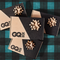 Stack of GQ Boxes with craft paper bows on a teal plaid background 