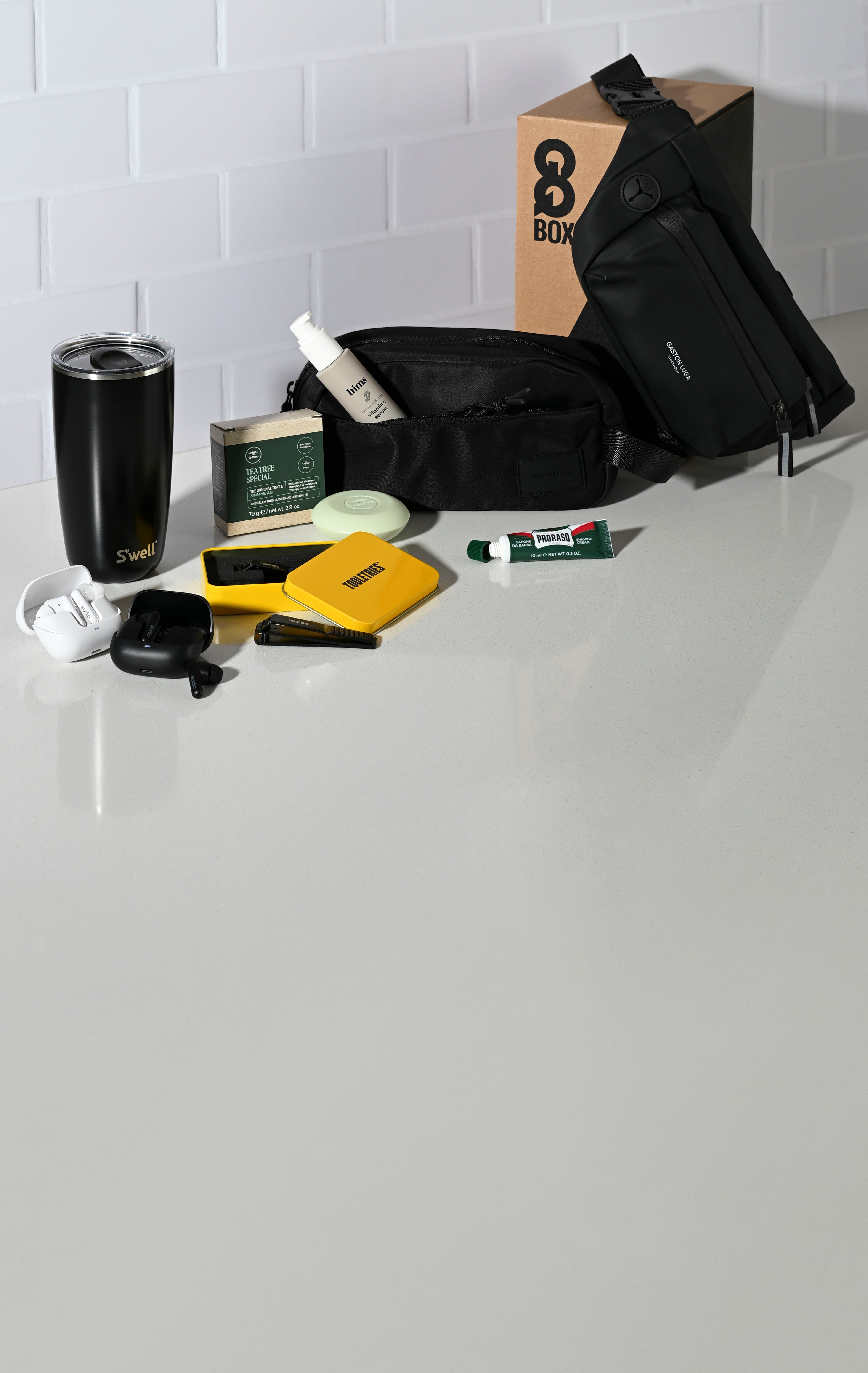 Collection of grooming products on a white surface with a branded box in the background.